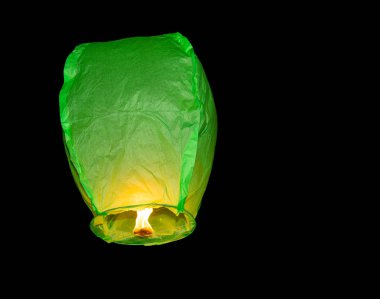 Karanlık gökyüzüne yüzen yeşil kağıt fener