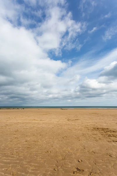 Písečná pláž s modrou oblohu při odlivu na Benllech v Anglesey, North Wales — Stock fotografie