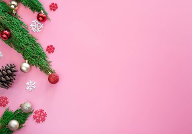 Yeşil çam, çam kozalağı, kar taneleri, kırmızı Noel süslemeleri topu pembe arka planda fotokopi alanı ile