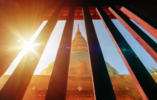 Vista de la pagoda de oro desde la ventana de la vendimia en Wat Phra Singh en Chiang Mai, Tailandia con destello de luz en la mañana. destino de viaje hito — Foto de Stock