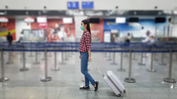Asiatisk turist med bagage, bär mask för att förhindra under restiden på flygplatsen terminalen för att skydda från den nya Coronavirus 2019 infektion utbrott situation — Stockfoto