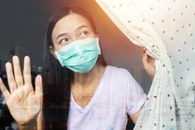 Ev karantina konsepti. Coronavirus enfeksiyonu kapmış bir kadın kendini karantinada tutma riskini göze alıp COVID-19 Coronavirus salgını sırasında mikropların yayılmasını önler.