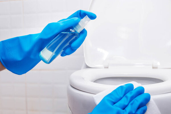 disinfect, sanitize, hygiene care. people using alcohol spray on toilet seat lid and frequently touched area for cleaning and disinfection, prevention of germs spreading during infections of COVID-19