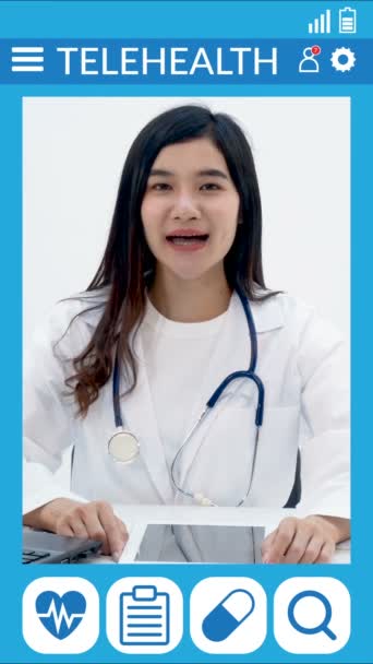オンラインの医者の相談だ アジアの医師は ビデオ通話でオンライン患者を相談するためにカメラに直接話します テレヘルスアプリのテンプレートを持つ病人に仮想ビデオチャットを行います — ストック動画