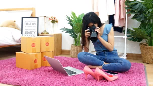 亚洲女人在家里的卧室里 通过手机在网上上传和销售鞋子 时尚配件的照片 在自我隔离期间在家里工作的小企业主 — 图库视频影像