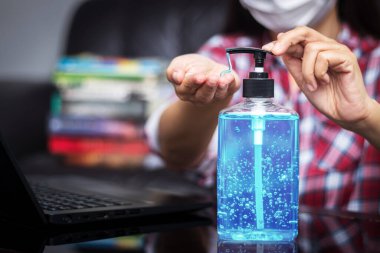 İnsanlar çalışmak için klavyeye yazmadan önce temizlik ve dezenfeksiyon için el temizleyicisiyle alkol jeli yıkıyorlar. COVID-19 Coronavirüs enfeksiyonları sırasında mikropların yayılmasını önlemek