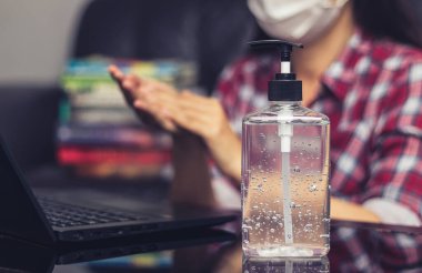 İnsanlar çalışmak için klavyeye yazmadan önce temizlik ve dezenfeksiyon için el temizleyicisiyle alkol jeli yıkıyorlar. COVID-19 Coronavirüs enfeksiyonları sırasında mikropların yayılmasını önlemek