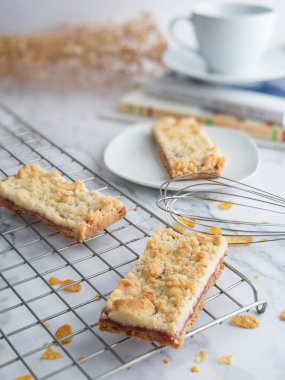 Pasta rafında reçel parçacıkları ve beyaz tabak, yumurta çırpıcısıyla süslenmiş, seçici odaklı. Taze ev yapımı fırın konsepti