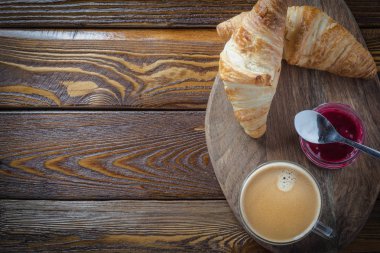 kruvasan ve ahşap masa üzerinde kahve fincan