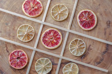 Dried red oranges, limes and lemons on wooden background with copy space