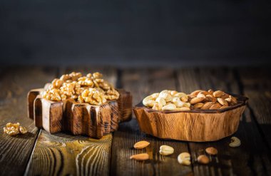 Hurma, ceviz, fındık, ahşap tabakta badem.