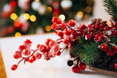  Şenlik masasında bir sepetin içinde noel süsü. Nar, ladin dalları, tarçın ve beyaz bir fincan.