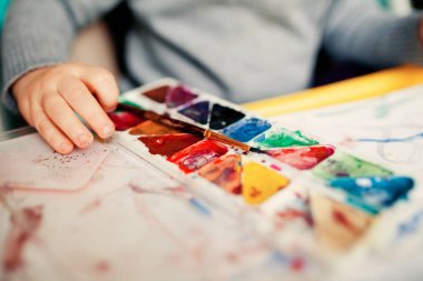 Küçük bir çocuk parmağıyla resim yapar. Çocuklarda iyi motor becerilerin erken gelişimi. En küçük çocuklar için sanat.