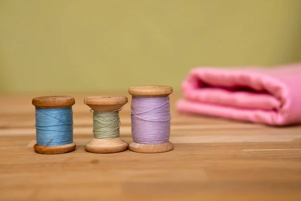 Set of tailoring accessories. Close up of a stack of folded pink fabric