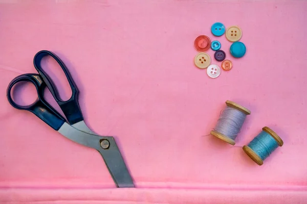 Set of tailoring accessories. Close up of a stack of folded pink fabric