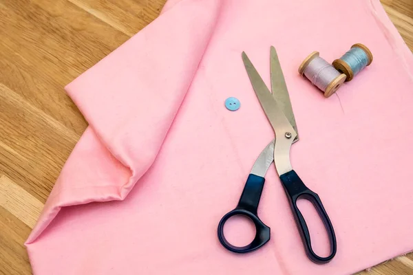 Set of tailoring accessories. Close up of a stack of folded pink fabric