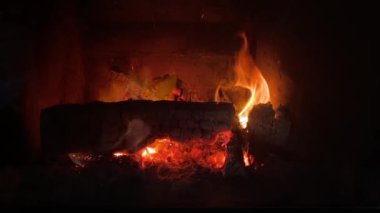 Sıcak alevler yakacak odunları yakıyor. Evin içindeki şöminenin içinde.