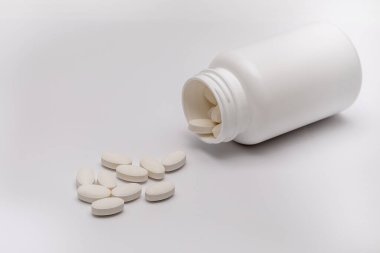 Beyaz yuvarlak kaplamalı tabletler plastik bir kutudan onlarla birlikte dağılmış. Uyuşturucu, hap..