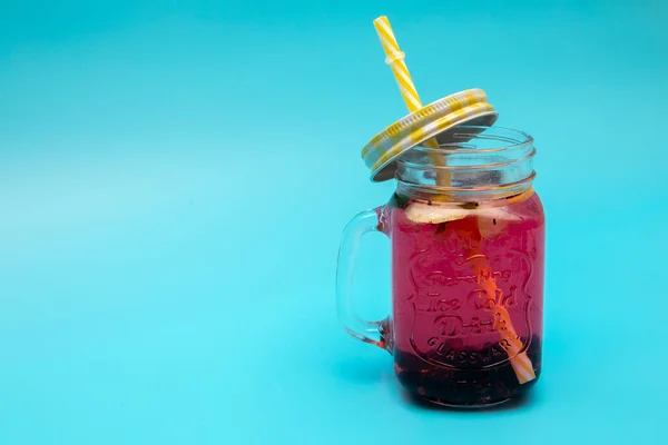 Uma Bebida Refrescante Bagas Limão Copo Com Boné Fundo Azul — Fotografia de Stock