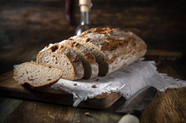 Tahta bir masada dilimlenmiş taze ekmek.