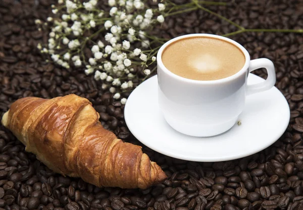 Λευκό Φλιτζάνι Καφέ Latte Και Κρουασάν Φόντο Κόκκων Καφέ — Φωτογραφία Αρχείου