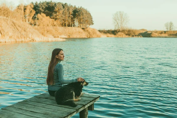 Uma Adolescente Está Sentada Com Cachorro Ponte Olhando Para Lago Fotos De Bancos De Imagens