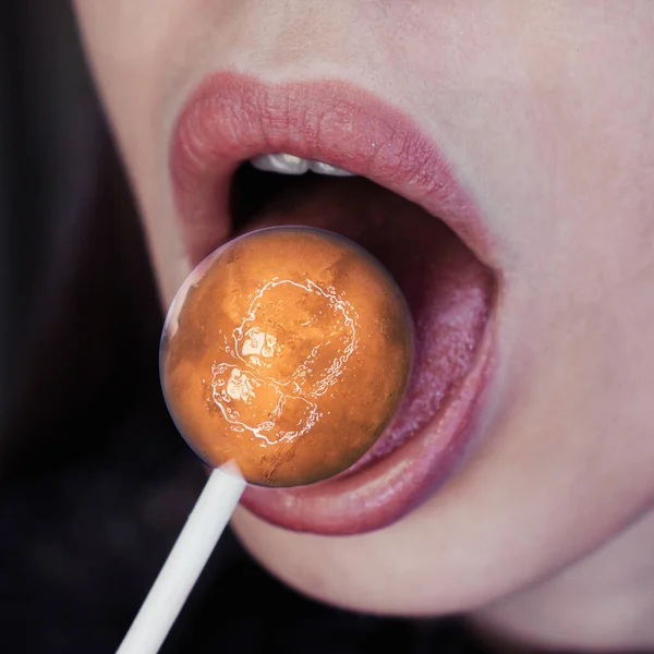 Female mouth with lollipop candy looks like a planet Mars — Stock Photo, Image