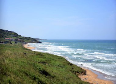 Sarı kumları ve parlak dalgaları olan Karadeniz kıyısının arka planı