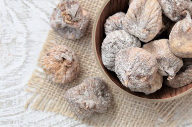 Ahşap masadaki bir tabakta kurumuş incirlerin arka planı