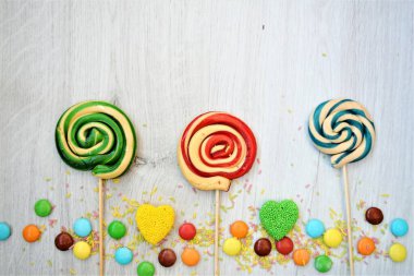 Tatillerde ve özel günlerde yazmak ve kutlamak için çerçeve, beyaz ve ahşap zemin üzerinde renkli şekerlerden yapılmıştır.