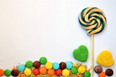 Tatillerde ve özel günlerde yazmak ve kutlamak için çerçeve, beyaz ve ahşap zemin üzerinde renkli şekerlerden yapılmıştır.