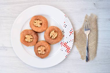 Kahvaltıda pastanın üst köşesi beyaz ahşap arka planda tabakta.