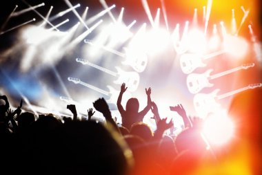 konserin siluetleri önünde parlak sahne ışıkları üzerinde kalabalık