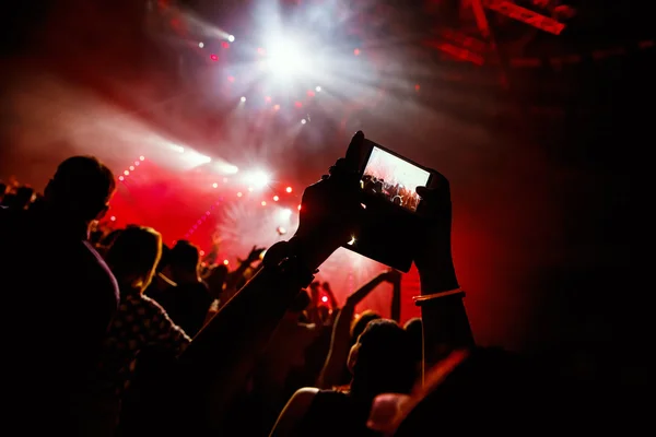 Mão com um smartphone grava festival de música ao vivo, tirando fotos do palco do concerto — Fotografia de Stock