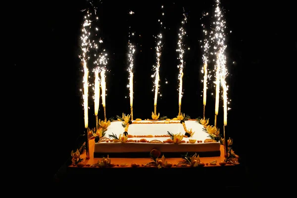 Birthday fruit cake with fireworks candles — Stock Photo, Image