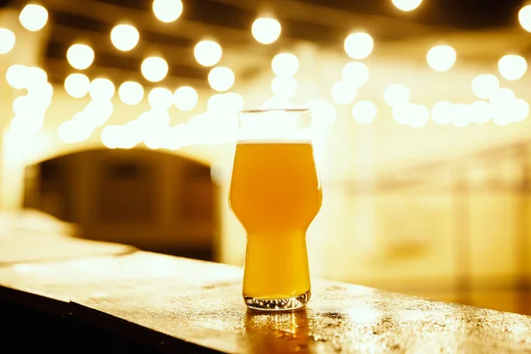 Um copo de cerveja de embalagem no fundo das lanternas — Fotografia de Stock