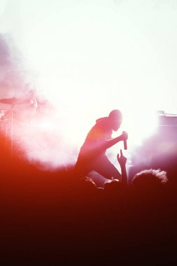 Bir sahnede mikrofon kalabalık bir konser solisti siluet şarkı