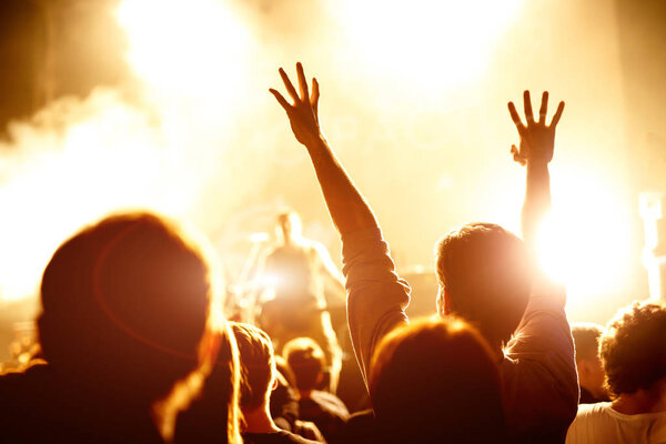 Cheering crowd at a rock concert, hands up