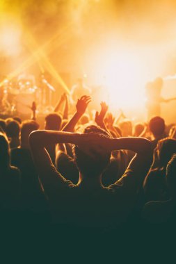 Rock konseri, parlak renkli sahne ışıkları önünde kalabalık tezahürat