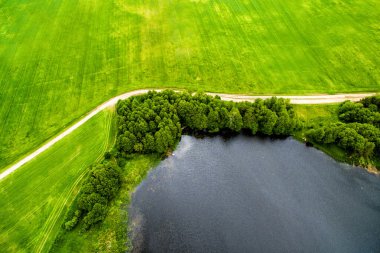 Drone görüntü. Yukarıdan bir doğal göl, yol ve alan bir görünüm