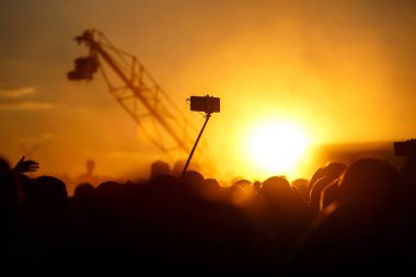 Bir smartphone bir sopa üzerinde bir yaz Müzik Festivali gün batımında