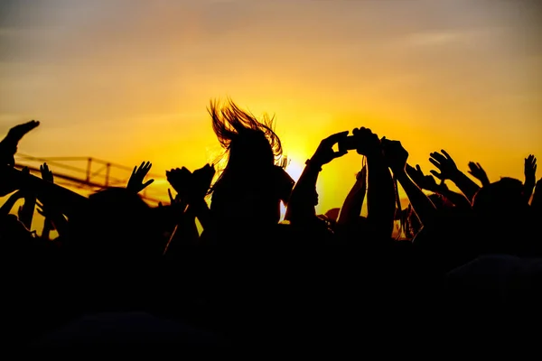 The crowd enjoys the summer music festival, the sunset