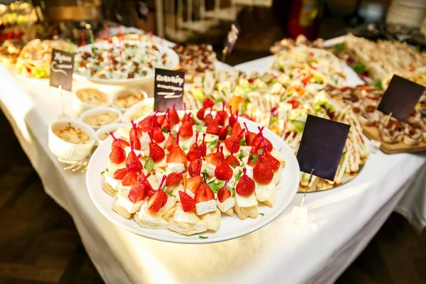 Catering para eventos. Muchos platos con carne, queso, fresas —  Fotos de Stock