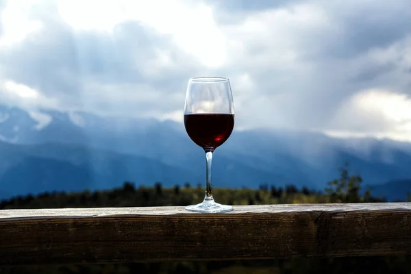 Kadeh kırmızı şarap ve arka planda dağlar. — Stok fotoğraf