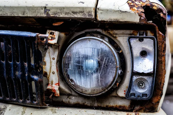 Detalhe do farol dianteiro de um carro velho na garagem — Fotografia de Stock