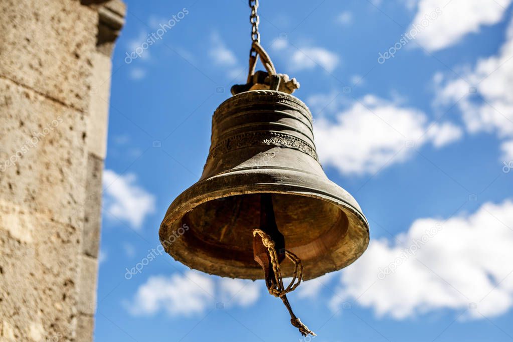 Orthodox bell closeup against the sky with clouds