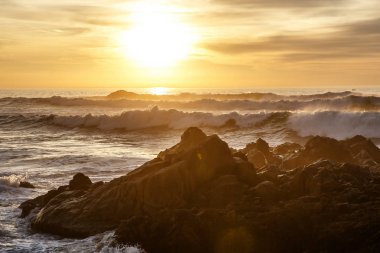 Sunset bulvarında kayalar üzerine çökmesini dalgalar deniz
