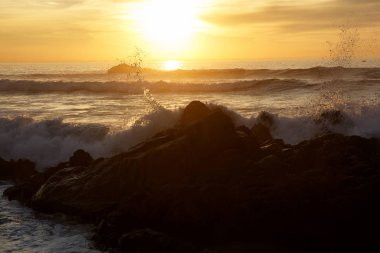 Sunset bulvarında kayalar üzerine çökmesini dalgalar deniz