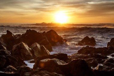 Sunset bulvarında kayalar üzerine çökmesini dalgalar deniz