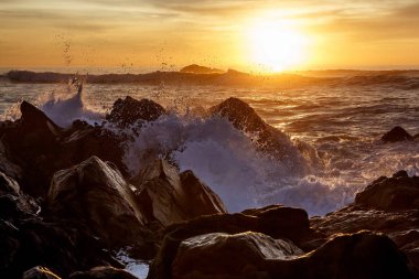 Sunset bulvarında kayalar üzerine çökmesini dalgalar deniz